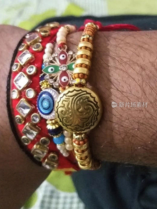 特写图像，Raksha Bandhan印度教节日，兄弟情谊和爱的手腕上的rakhi弦手镯，一个不认识的印度人的手腕，提升的观点